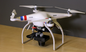 The drone-camera rig used to create the model of the dig site. A DJI Phantom 2 quad copter and a 12.1 megapixel Canon Powershot SX260 HS that has a built-in GPS chip that records the locations of each photograph.  Photo courtesy of the authors.